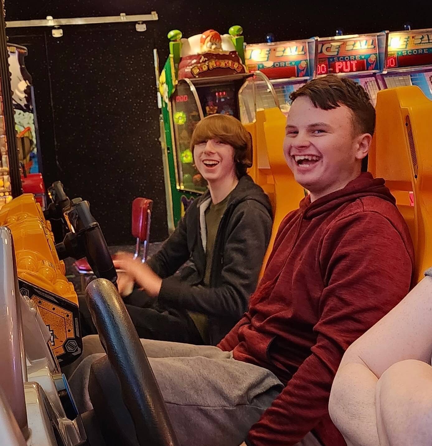 Two teen boys at an arcade smiling