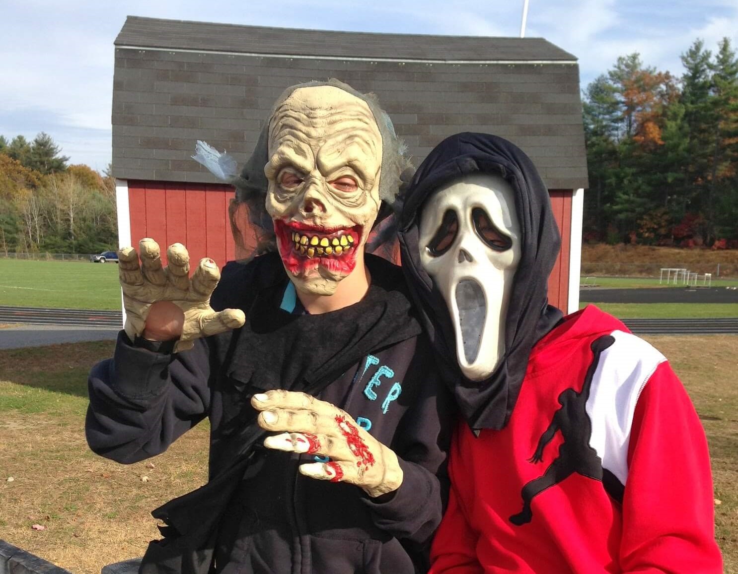 Two friends dressed up for Halloween. Both are monsters and one is from the movie Scream