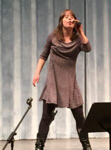 Nadine's daughter singing into microphone