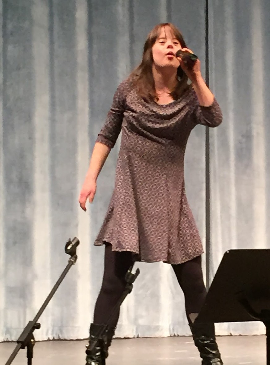 Nadine's daughter singing into microphone